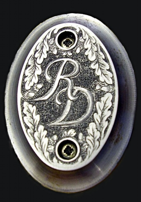 Monogramm als Relief auf Pistolengriffkäppchen-Eichenlaubornamentik